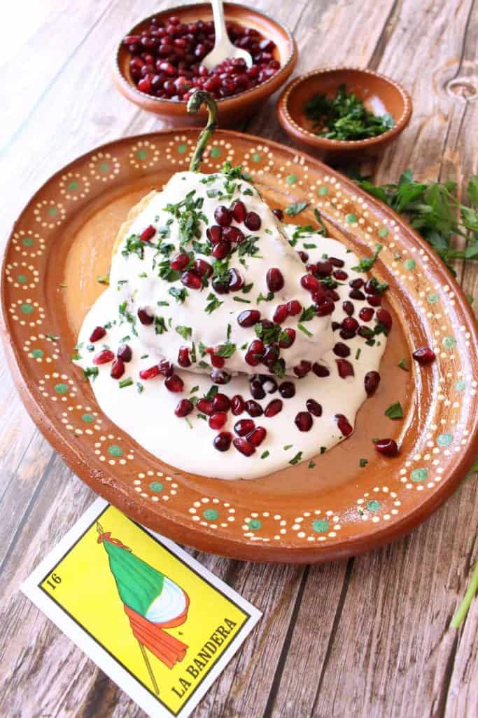 stuffed pepper drenched in white sauce topped with pomegranate seeds.