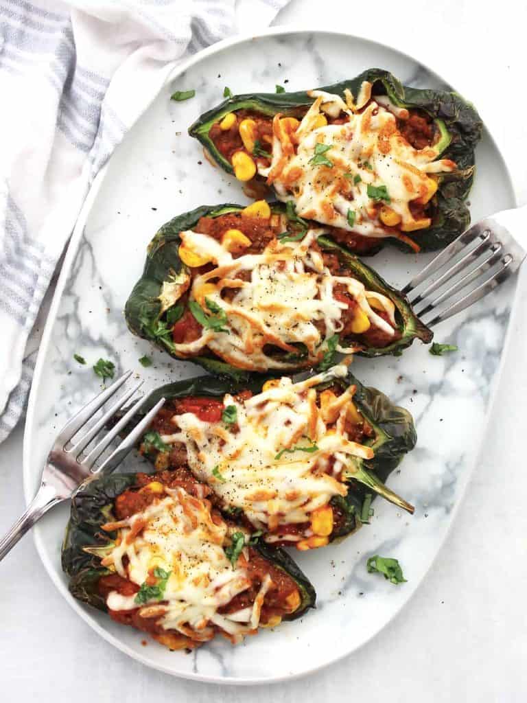 four stuffed pepper halves on a plate.