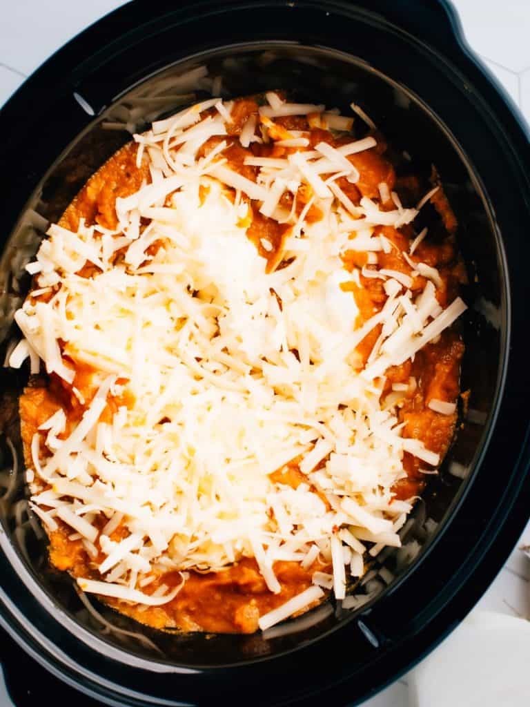 crock pot filled with cheesy enchiladas.