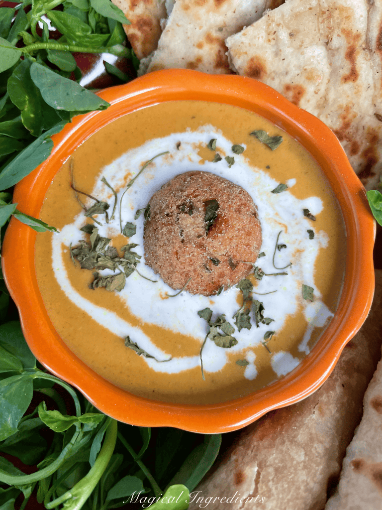 bowl of soup with a large dumpling in the center.