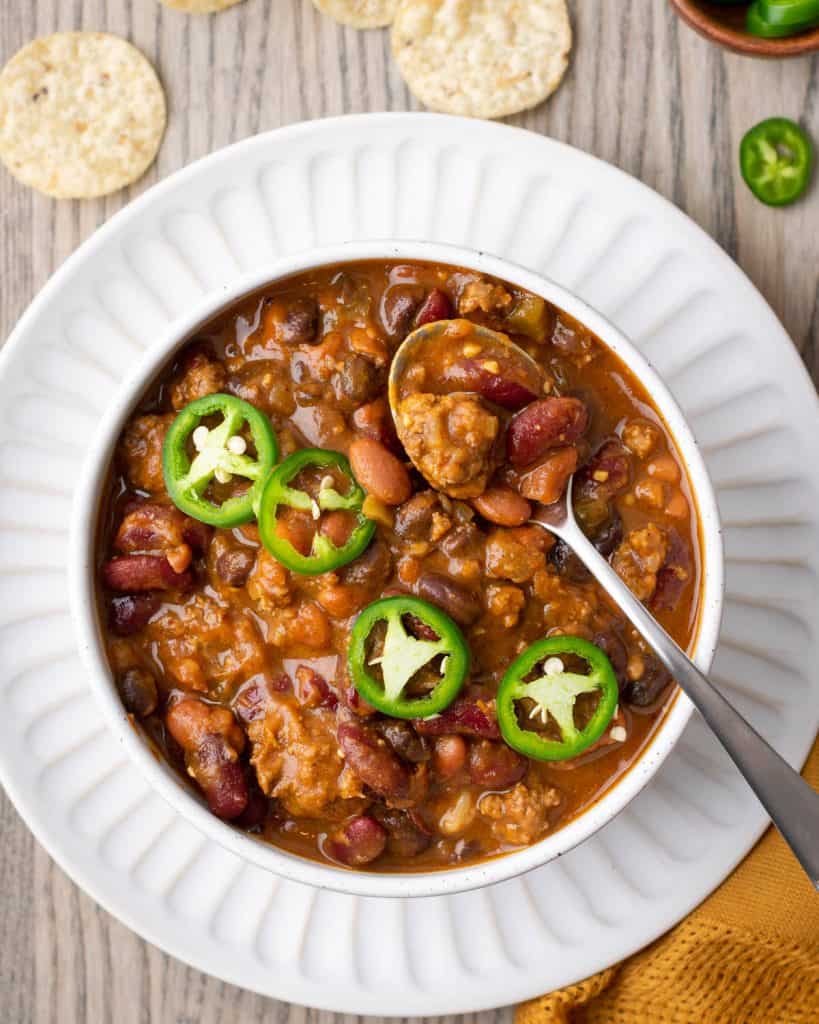  bowl of chili topped with jalapeno rings.