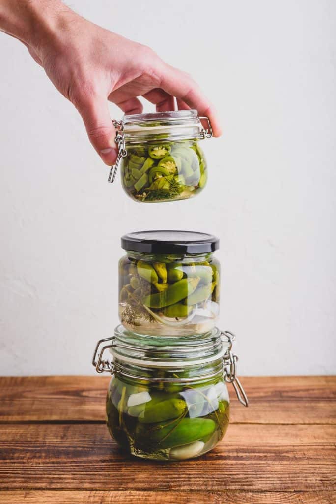 photo of three small jars of pickled jalapenos, stacked.