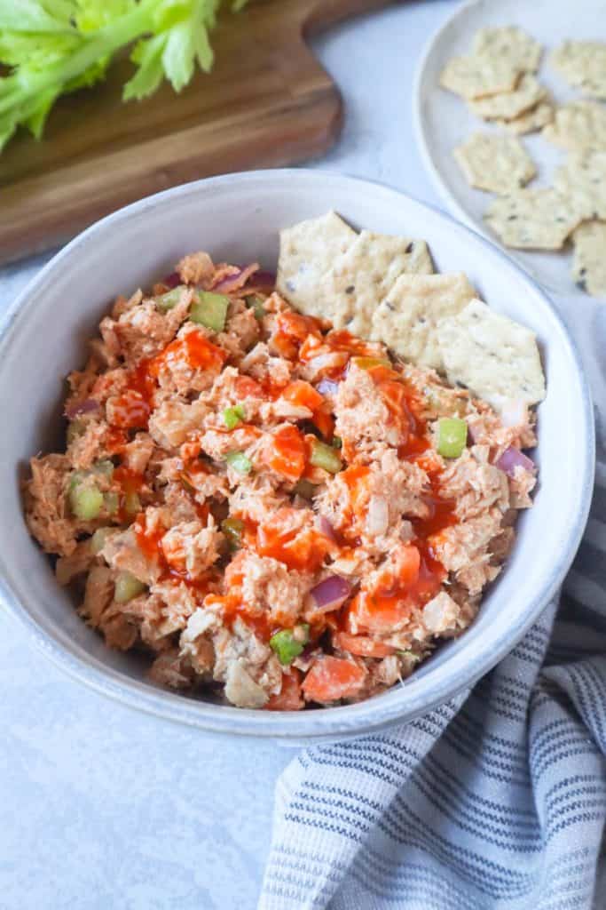 bowl filled with spicy tuna mix and crackers.