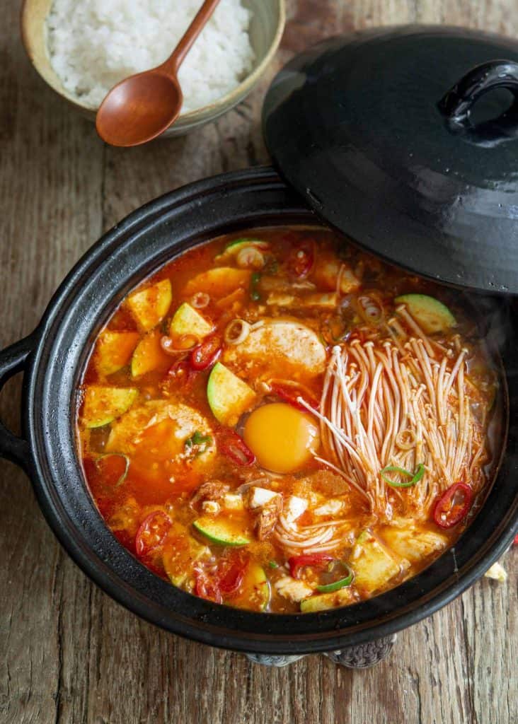 big pot of soup with enoki mushrooms and egg.