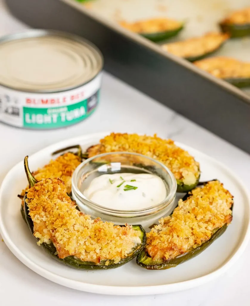 stuffed jalapenos with dip in front of can of tuna.