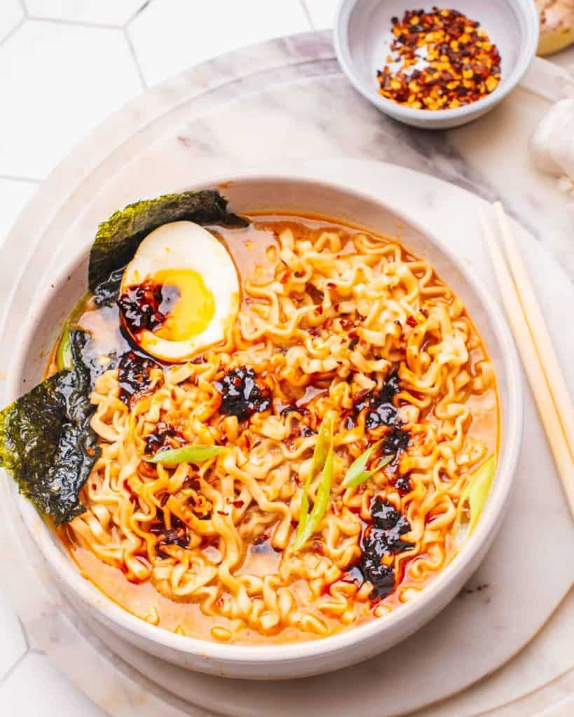 bowl of spicy ramen with egg and seaweed.