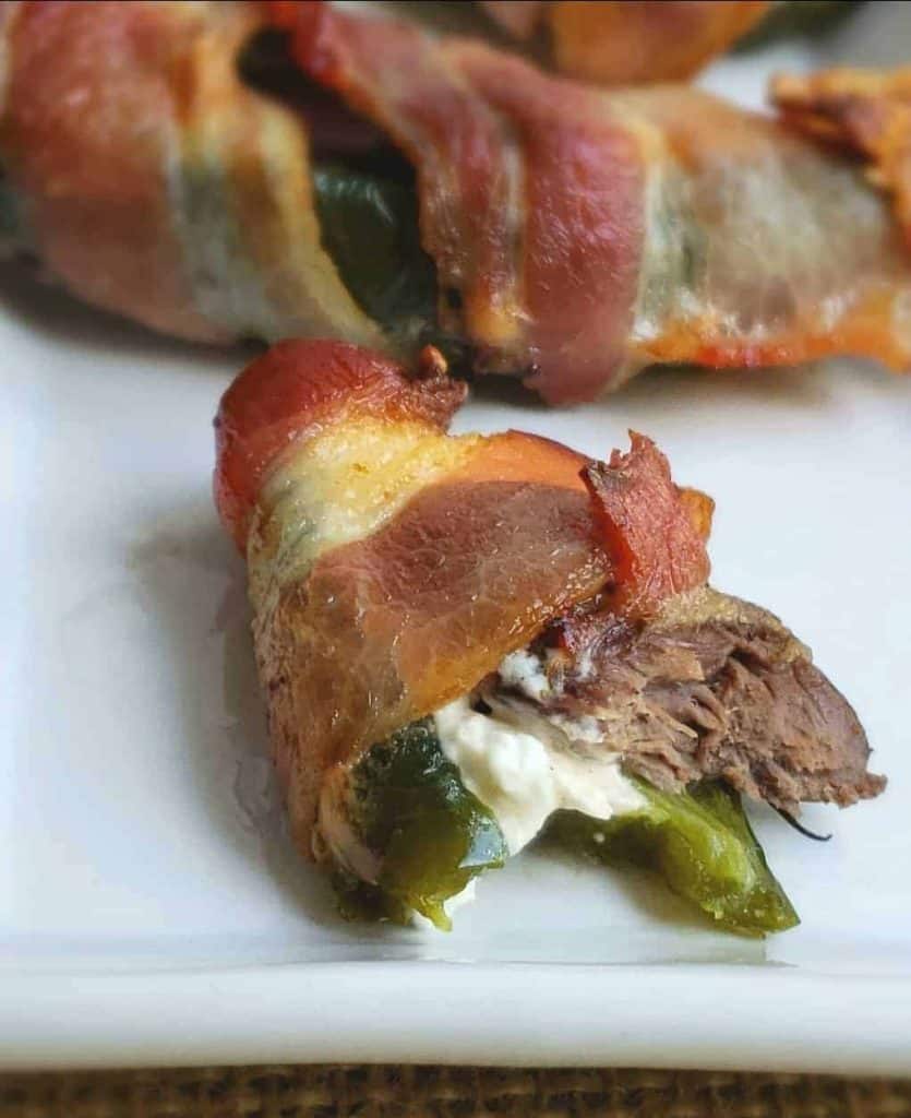 jalapeno popper with dove meat wrapped in bacon, with a bite taken out of it.